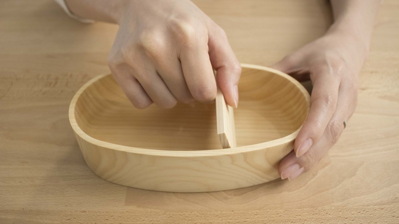 紀州ひのきの弁当箱(小)にしきりを入れている様子